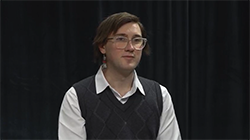 Headshot of Phoenix Knipe in front of a black curtain backdrop
