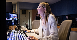 Broadcast and Cinematic Arts student Sarah Kelly working at a switchboard in the MHTV studio