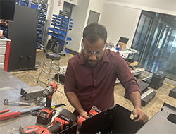 Graduate student Sashi Maddikunta using power tools to repair a cabinet