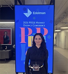Integrative Public Relations student Teagan Kazim standing in front of a sign at the 2026 PRSSA Midwest District Conference