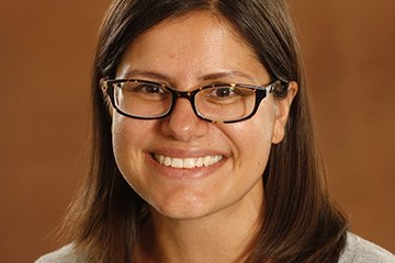 Dr. Kirsten Weber on a warm golden backdrop.