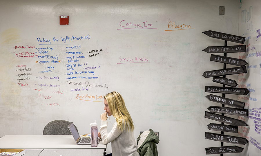 Advertising student in workspace with ideas written on the whiteboard.