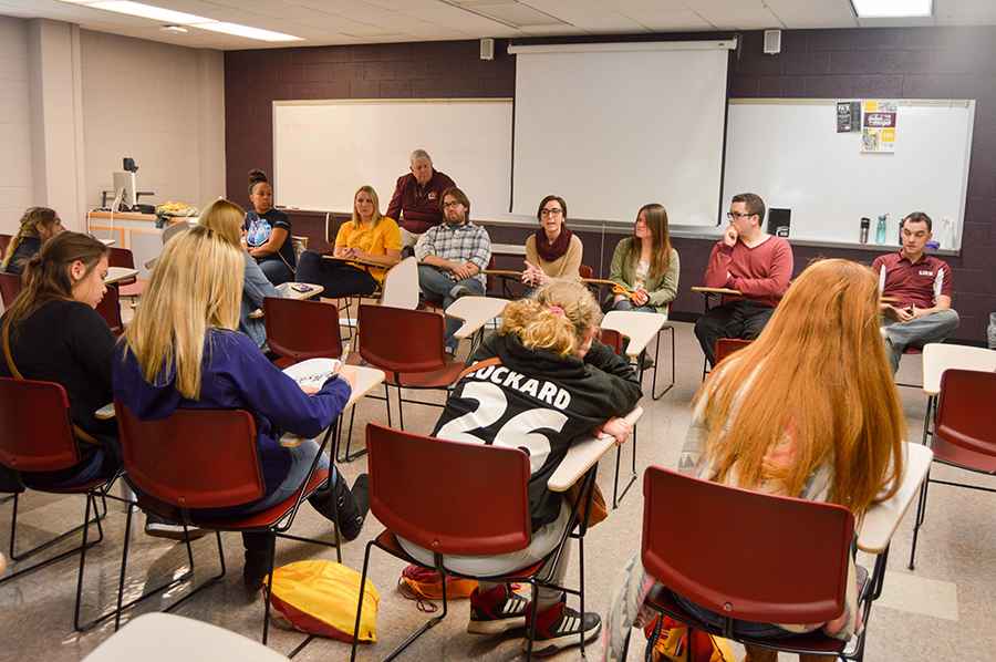 Students in a journalism classroom having a discussion.