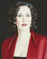 Headshot of Laure Meloy on a black backdrop.