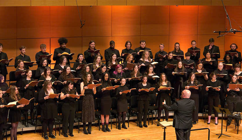 A picture of the CMU Choirs, under the direction of Dr. Eady, performing in Staples Family Concert Hall.