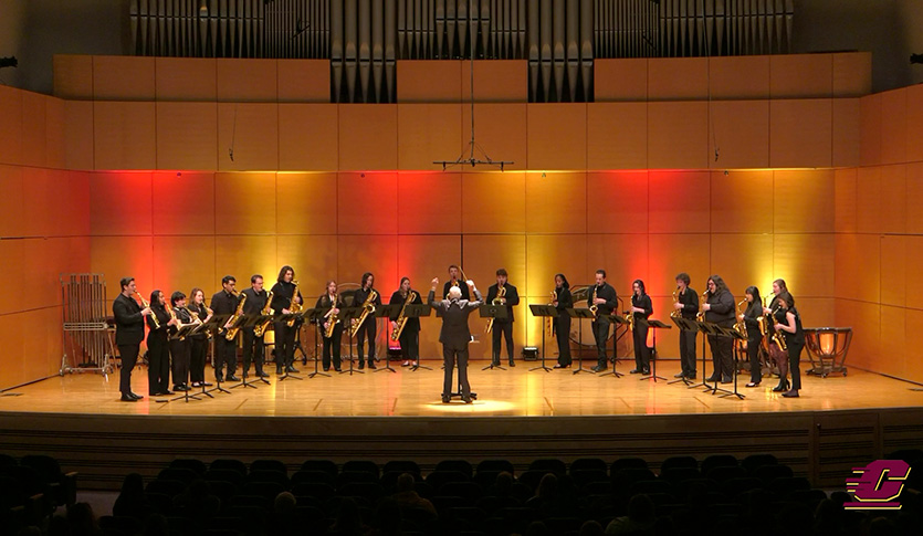 The CMU Saxophone Ensemble stands as they perform on stage at Staples Family Concert Hall under the direction of Professor John Nichol.