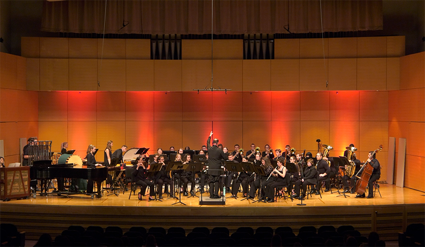 The CMU Symphonic Wind Ensemble performing on stage at Staples Family Concert Hall under the direction of Dr. Christopher Chapman.