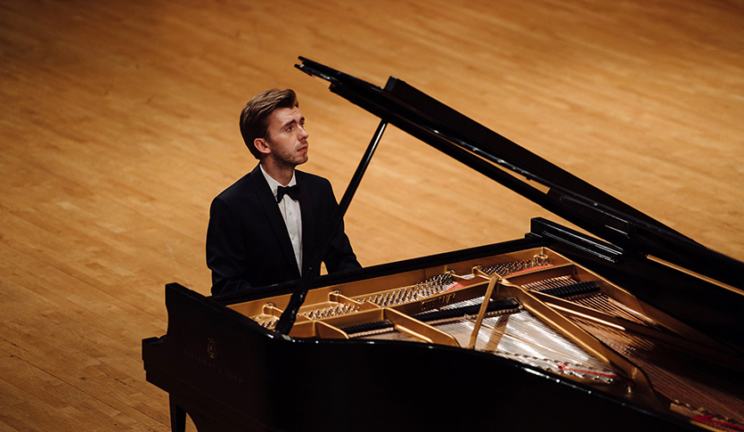 Pianist Igor Lipinski playing in a concert hall.