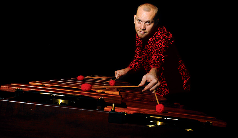 Percussionist Von Hansen playing the marimba in a dark room.