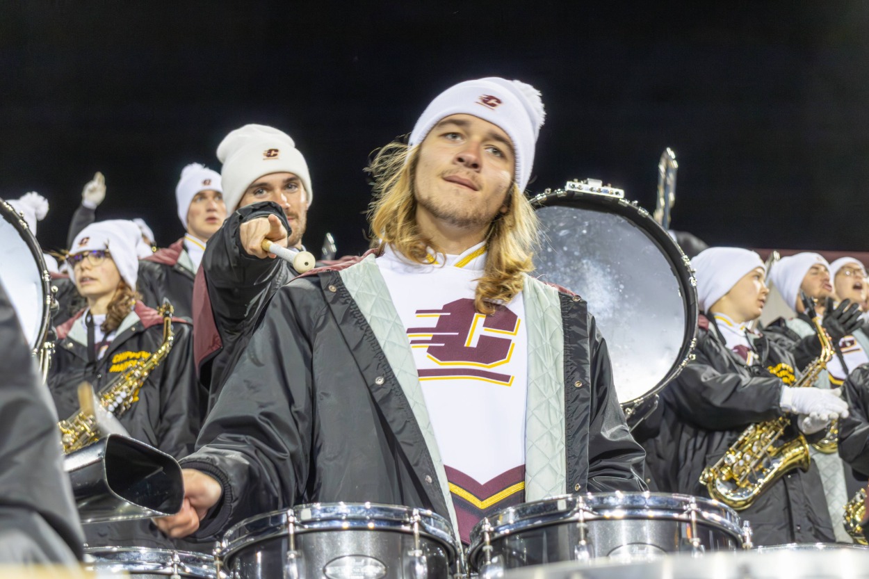 a group of people playing instruments with a percussionist pointing at the camera