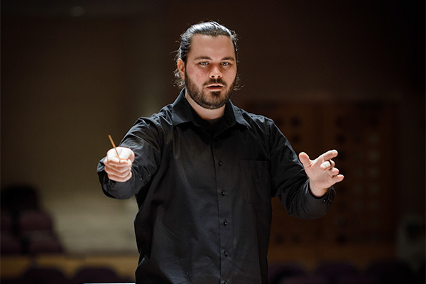 A picture of a CMU Music Student conducting