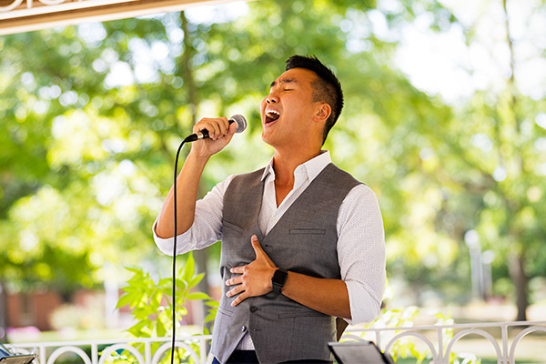 A picture of a student singing outdoors