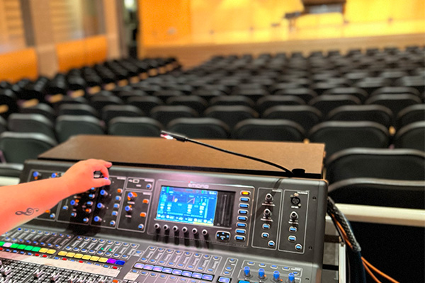 A picture of part of a mixing board in a concert hall