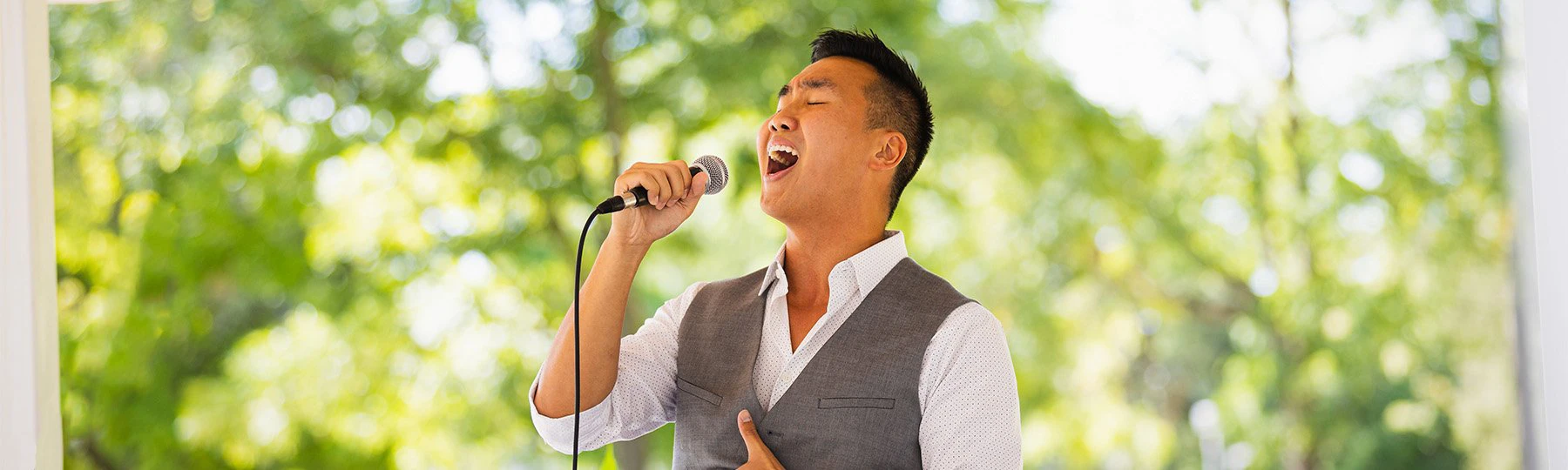 A picture of a music student at Central Michigan University singing outdoors