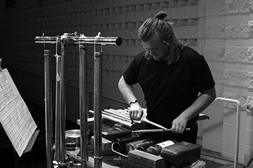 Black and white image of Landon Schumacker playing percussion on stage.