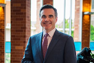 Headshot of Jonathan Nichol with a row of windows bringing in natural light behind him.