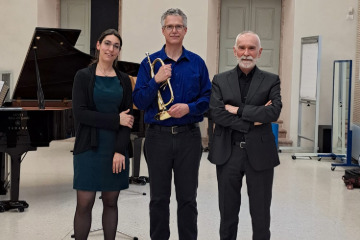 3 Individuals smiling and dressed in concert performance attire. From left to right stands Francesca Carola, pianist, Neil Mueller, trumpet, and Ivano Ascari, trumpet.