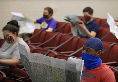 Students sitting in a classroom and looking at large pieces paper