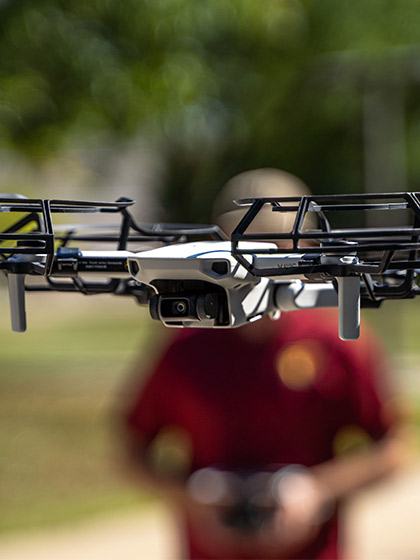 Close-up of a student flying a drone.