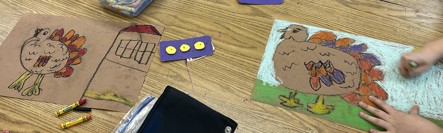 Children's drawings of turkeys on a table.