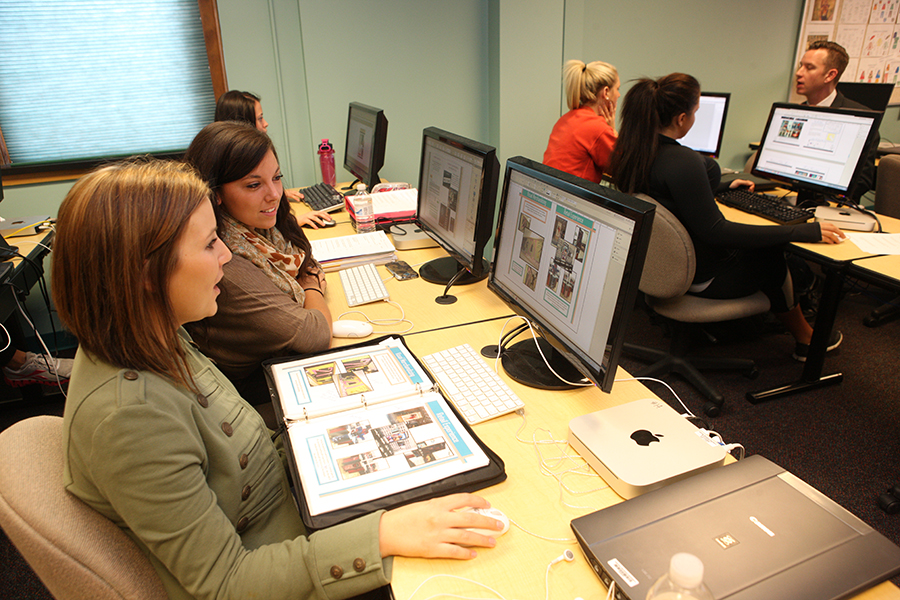 Students working in a computer lab to set the layout for the next magazine issue.