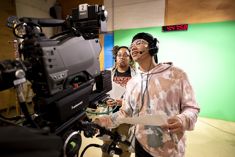 Two students use a television camera at the campus tv station.
