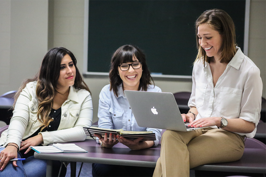 Three students are working together on an article for the campus magazine.