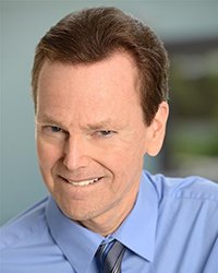 Headshot of Brad Slaight. He's wearing a blue shirt and tie.