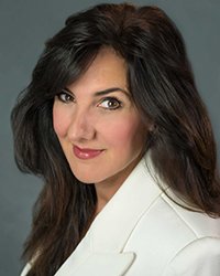 Headshot of Christine Cashen on a soft grey backdrop.