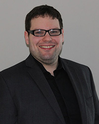 Headshot of Jason Dizik with a grey backdrop.