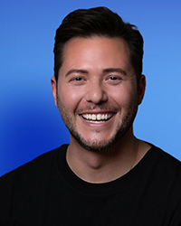 Headshot of Joel Lecz on a bright blue backdrop.