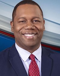 Headshot of Matt Franklin with a grey, red and blue lined pattern in the background.