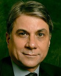 Headshot of Pete Engardio on a dark green backdrop.