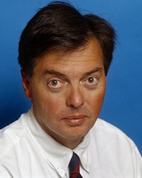 Headshot of Peter Luke set in front of a blue backdrop.