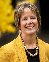 Headshot of Sherry Knight. You can see golden leaves on a tree in the background.