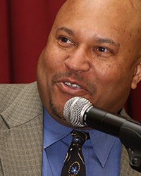 Headshot of Terry Foster, He is speaking into a microphone.