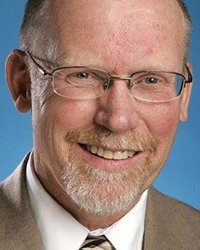 Headshot of Jim Harger with a blue backdrop.