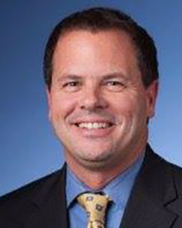 Headshot of Tony Cervone on a blue backdrop.