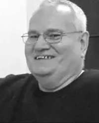 Greyscale headshot of c Marshall Matlock, laughing