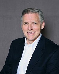 Headshot of Brett Holey with a dark grey backdrop