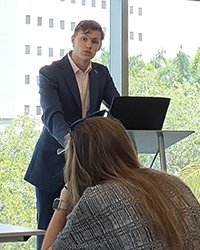 Mason Pickard standing at a debate podium in front of an audience.