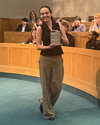 Freshman Raegan D., Second Place Speaker, Novice Public Forum accepting her award