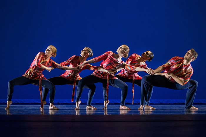 Group of CMU University Theatre Dance Company students performing  a dance up on the stage on the campus of Central Michigan University.