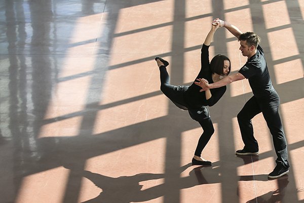 Dance couple dancing in the sunlight, casting shadows