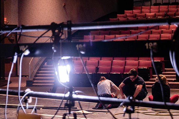 Students building a set with a light shining on them.