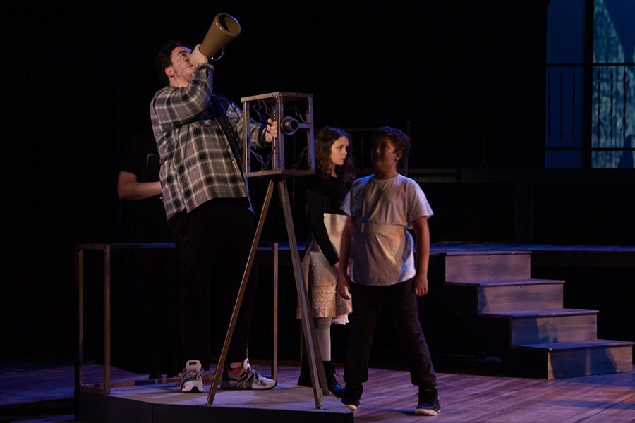 20221104_actdirect_tad_001_900x600 Student on stage, acting as a director with two other students beside him.