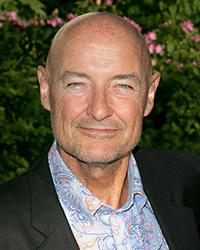 Headshot of Terry O'Quinn with flowered plants in the background.