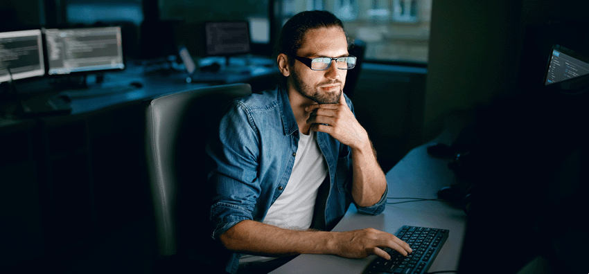 IT Bootcamps Central Michigan University 850x396 Man sitting at a desk working on a computer