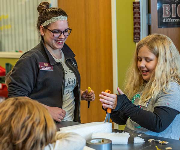 STEM student helping a young girl