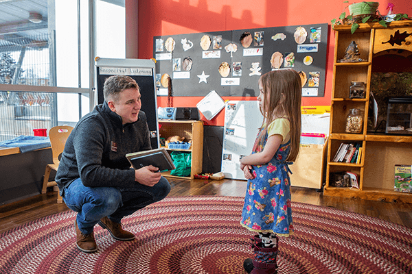 Child development and learning laboratory teacher talking to child.